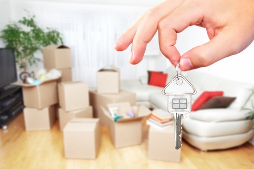 Moving crew carrying household items through a Battersea residential building